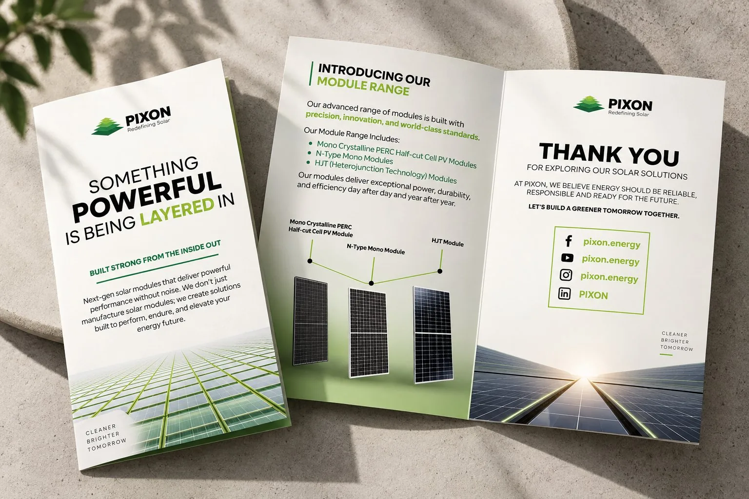 The PIXON company brochure open on a stone surface, showing the cover, module range and thank-you pages